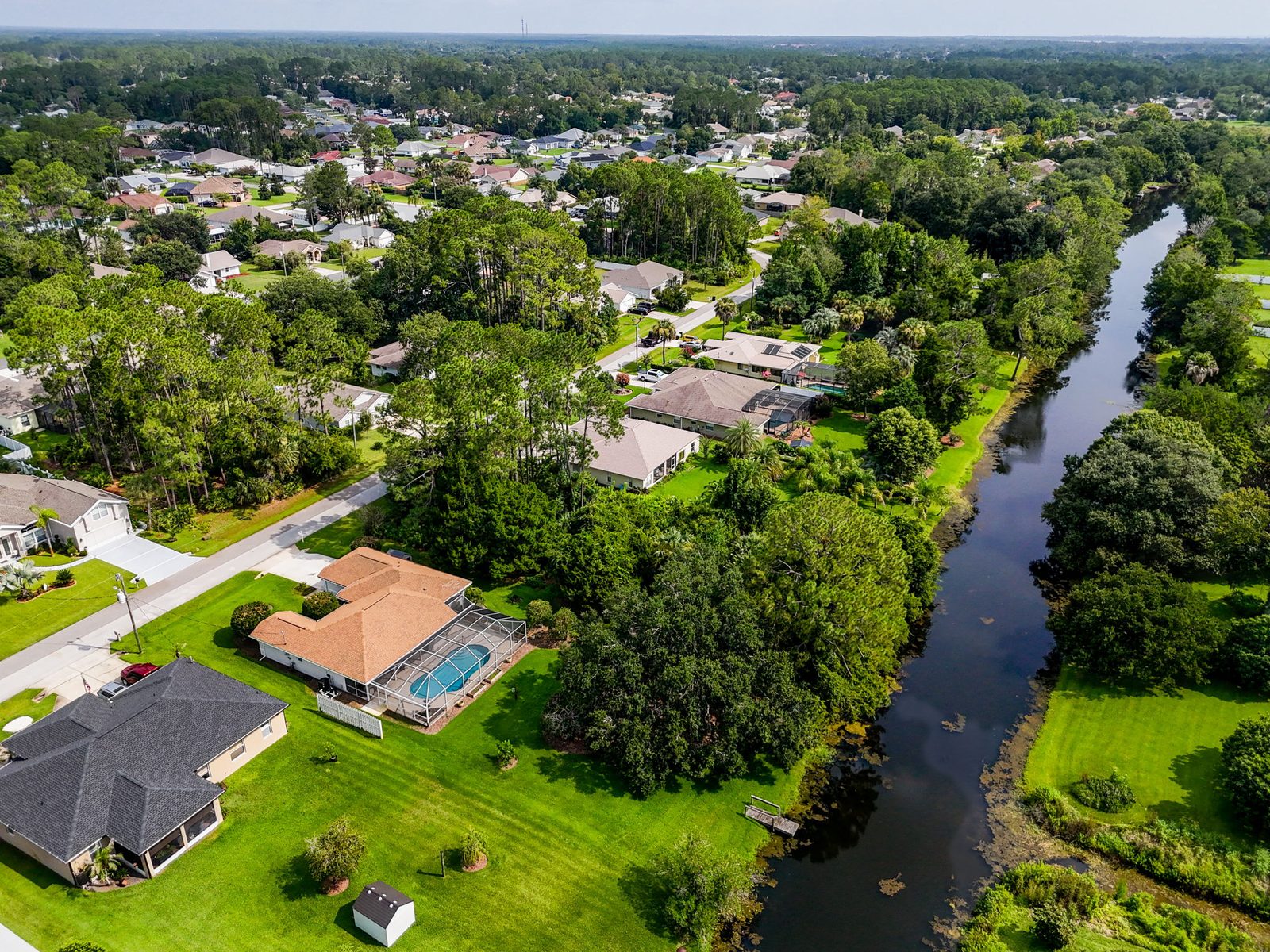 Wide aerial view of the neighborhood and freshwater canal behind 62 Bayside Dr